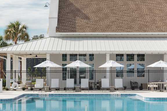 A pool with a white building behind it.