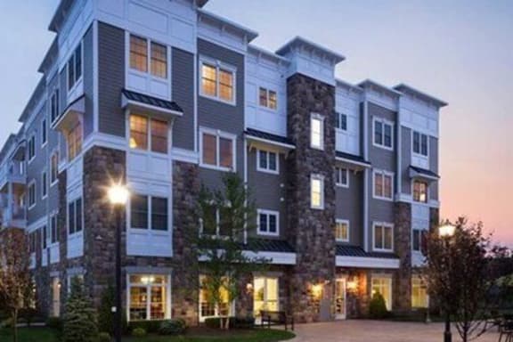 an apartment building is lit up at dusk