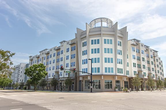 a large white building on the corner of a street with a blue sky in the background