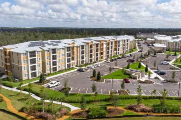 an aerial view of an apartment complex with a parking lot