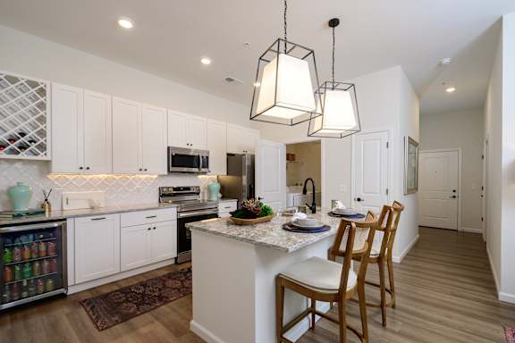 A kitchen with a table and chairs in the middle of it.