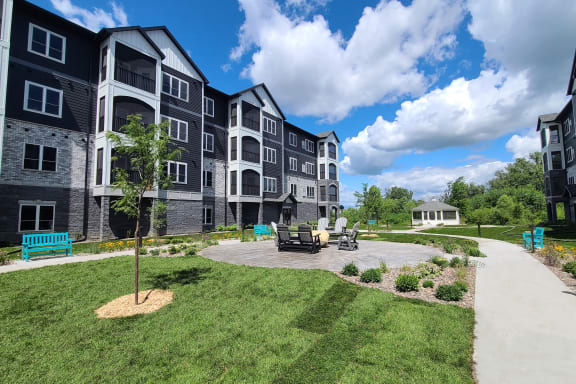 an exterior view of an apartment building with a patio and landscaping