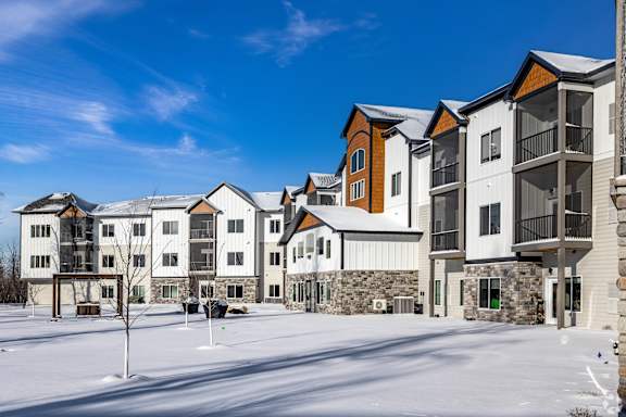 A row of modern houses with a snowy ground in front.