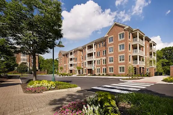 A large brick building with a landscaped garden in front.