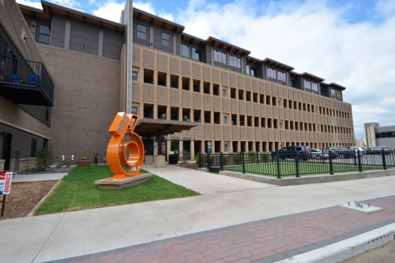 a large building with an orange sculpture in front of it