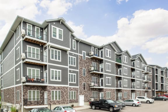 a large apartment building with cars parked in front of it