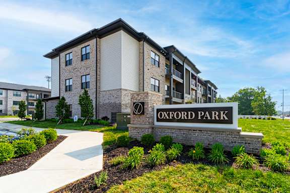 A sign that says Oxford Park in front of some buildings.