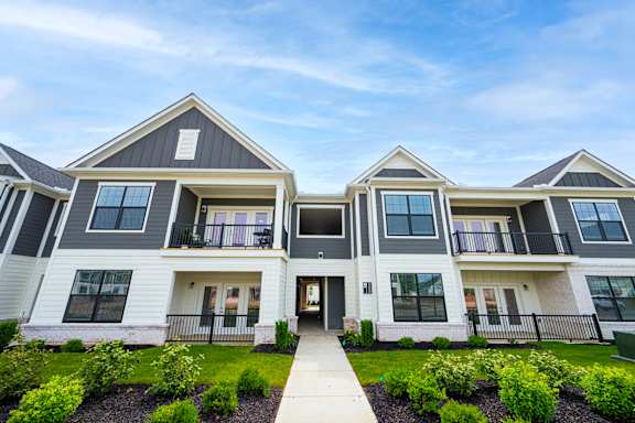 A modern two-story house with a front yard and landscaping.