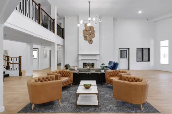 the living room has leather chairs and a fireplace
