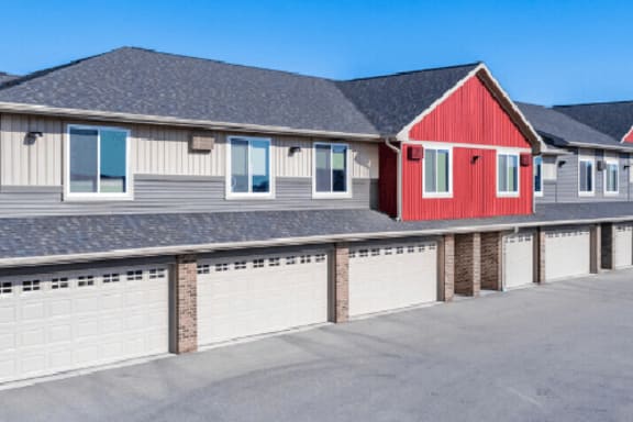 a house with a red garage door and a row of garages