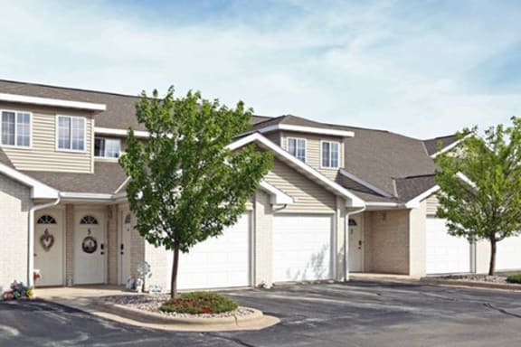 a house with two garage doors and a tree