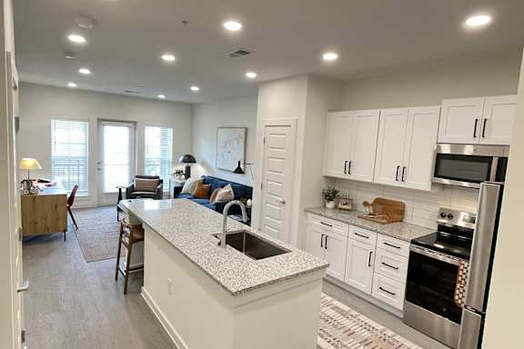 A kitchen with white cabinets and a large island.