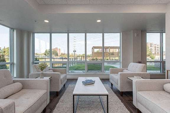 A living room with white furniture and a view of the outside.