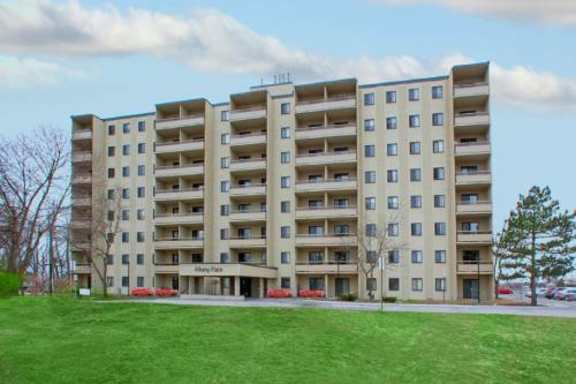 A large apartment building with a green lawn in front.