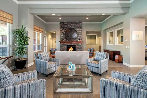 A living room with a fireplace and striped couches.