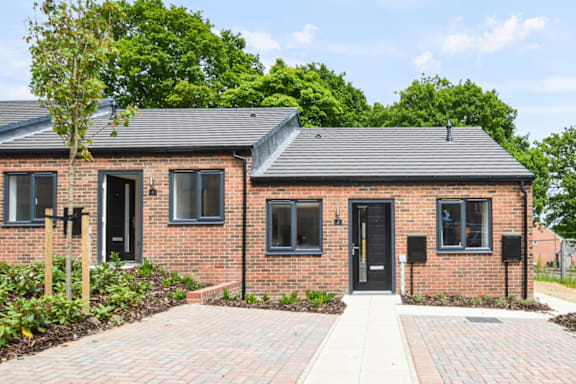 A brick house with a black door and windows.