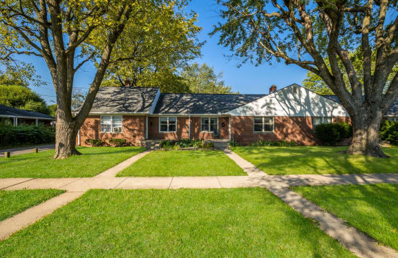 a red brick house with trees in front of it
