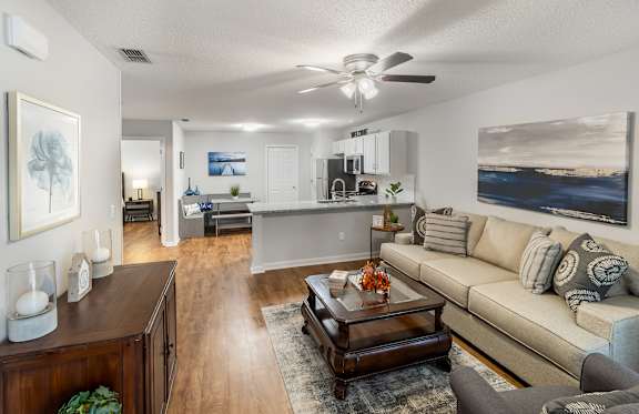 A living room with a couch, coffee table, and a painting on the wall.