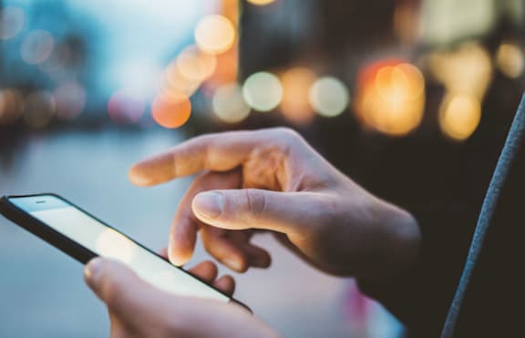 A Person's Hands Holding a Smartphone at Capitol Grove Apartments, Des Moines, IA, 50317