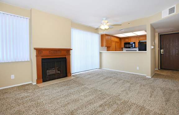 A room with a carpeted floor and a ceiling fan.