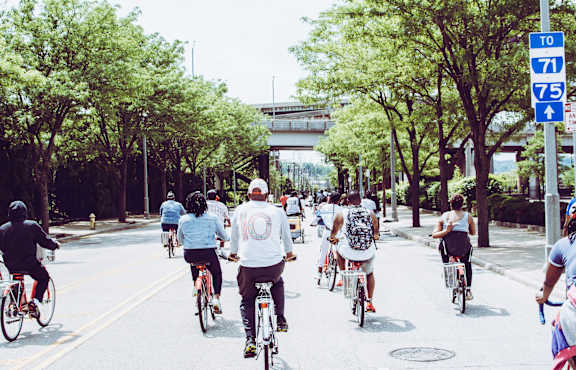 A group of people riding bikes down a street.