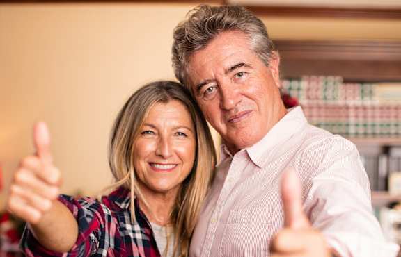 A man and a woman giving a thumbs up.