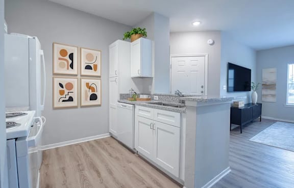 A white kitchen with a refrigerator, oven, and cabinets.