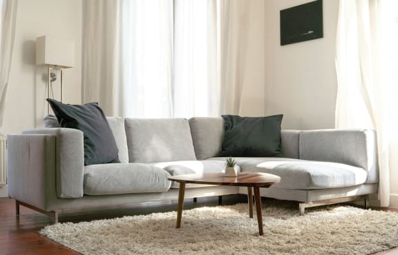 an empty living room with a window and a ceiling fan