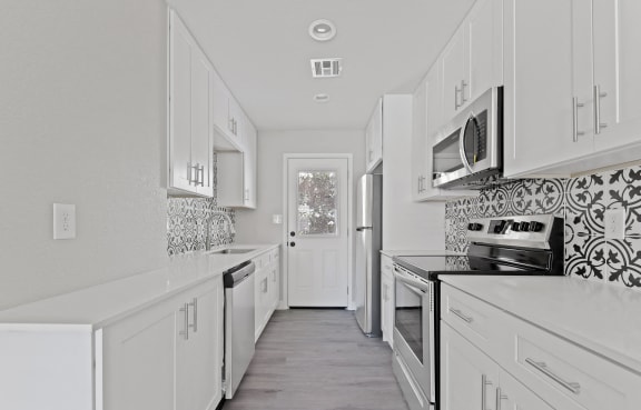 a white kitchen with white cabinets and white appliances