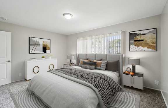 A bedroom with a large bed and two nightstands.