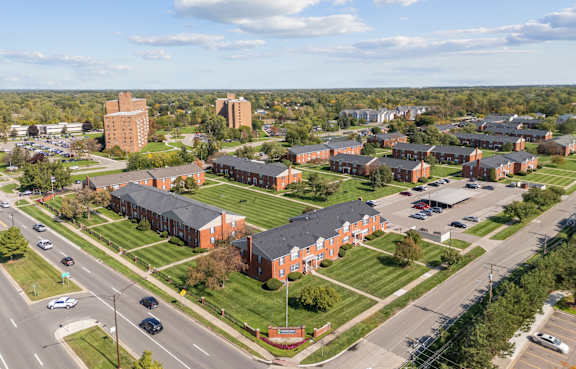 Fenced dog park with green lawn at Canterbury Square Apartments, Troy