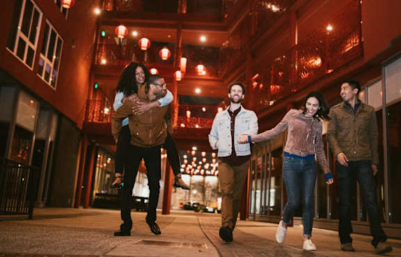 A group of people are walking down a street holding hands.