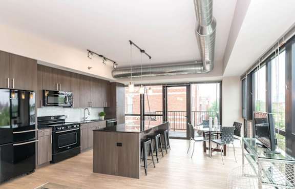 A modern kitchen with dark wood cabinets and black appliances.
