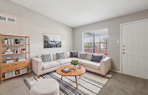 A living room with a white couch, a wooden coffee table, and a bookshelf.