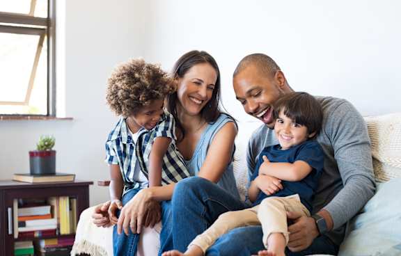 a family sitting on a couch with their children