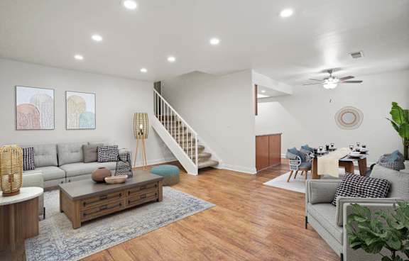 A modern living room with a grey rug and a grey sofa.