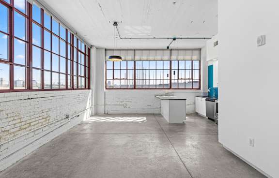 a kitchen and dining area with large windows and a table and chairs