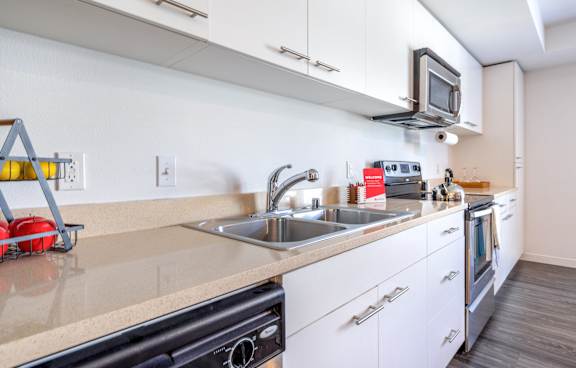 A modern kitchen with white cabinets and a black oven.