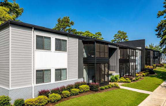 A modern house with a grey exterior and a well-manicured lawn.