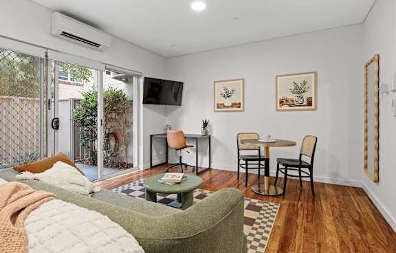 a living room with a green couch and a balcony
