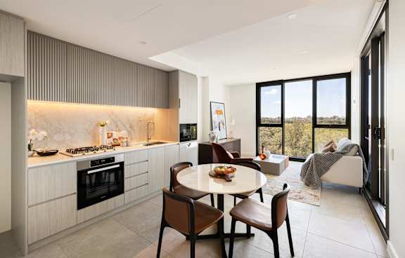 a living room with a green couch and a balcony