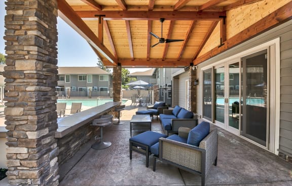 a covered patio with furniture and a pool in the background