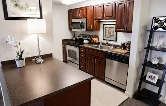 A kitchen with brown cabinets and a brown counter top.