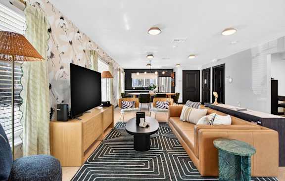A modern living room with a large sofa, a coffee table, and a television.