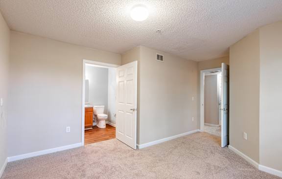 A room with a ceiling fan and a door.