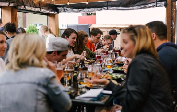 a group of people sitting at a table eating food