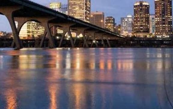 a bridge over a river with a city in the background