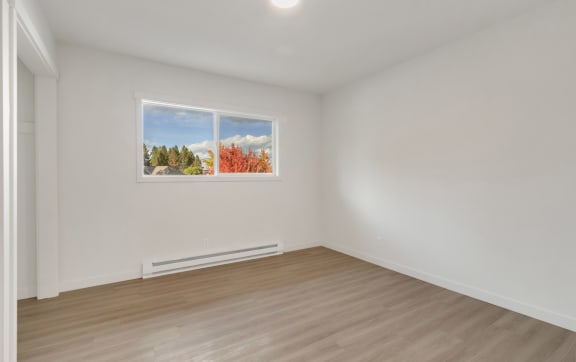 a living room with white walls and a window