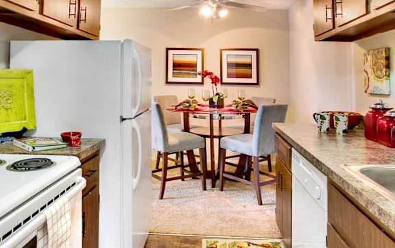 A kitchen with a table and chairs in the middle.