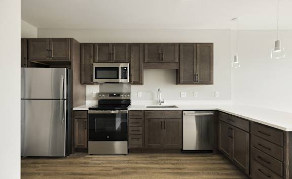 A kitchen with brown cabinets and stainless steel appliances.